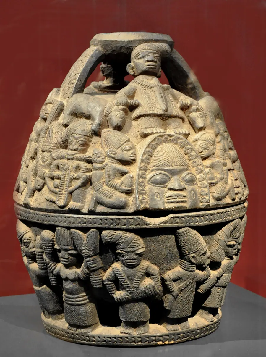 Carved circular wooden divination tray with a face at the top edge and figures around the rim.
