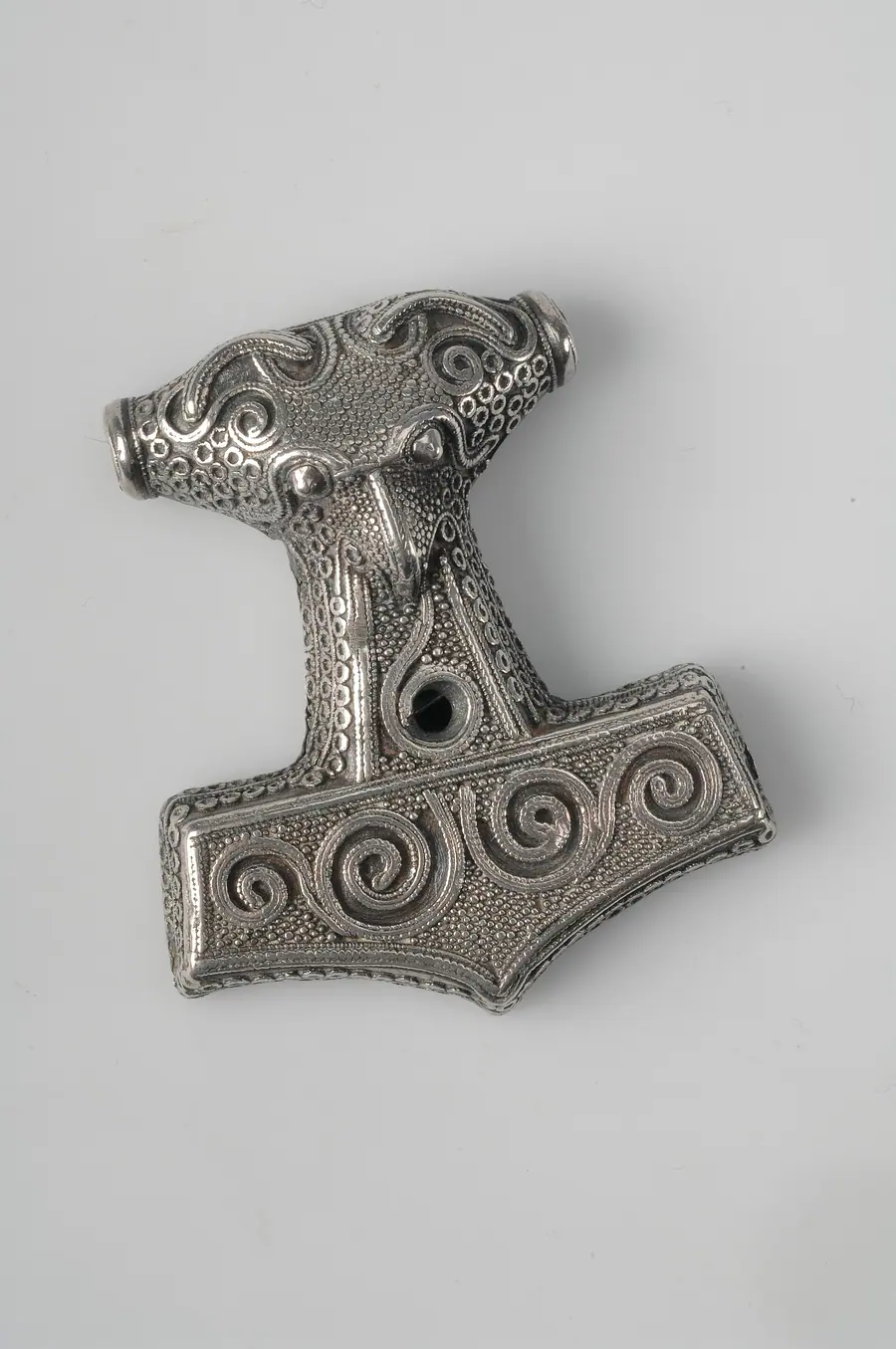 Small silver hammer-shaped pendant with punched decoration.