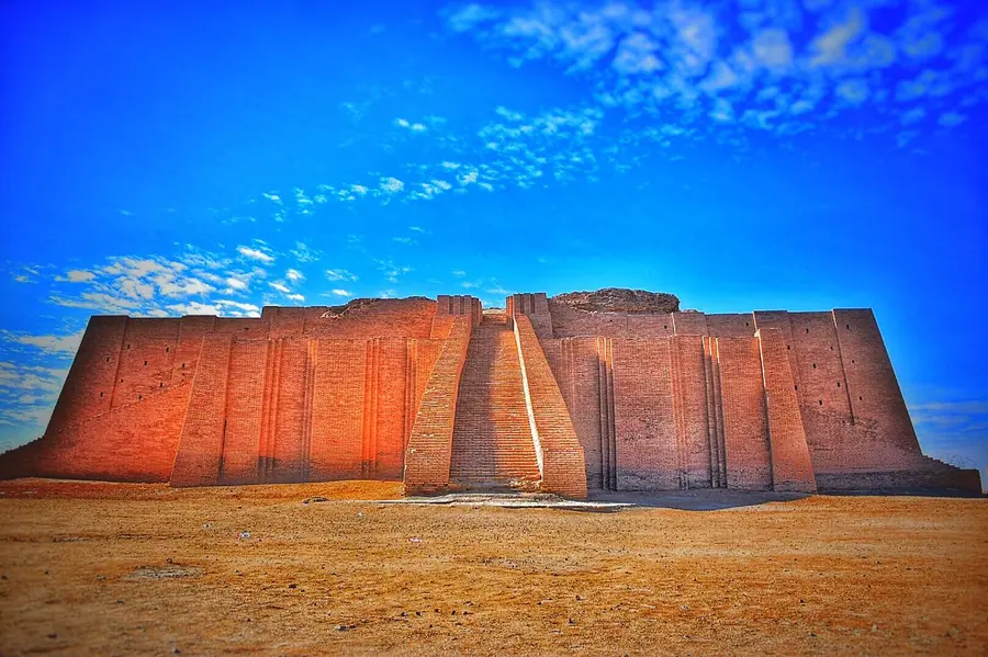 Reconstructed mud-brick stepped platform rising from flat desert.